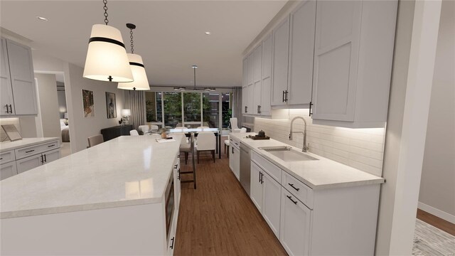 kitchen featuring a sink, tasteful backsplash, stainless steel dishwasher, wood finished floors, and light countertops