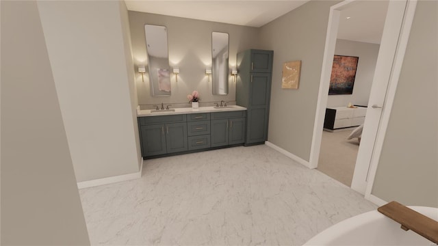 full bath with a sink, marble finish floor, and double vanity