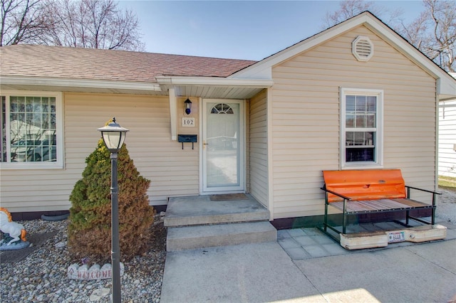 doorway to property featuring a shingled roof