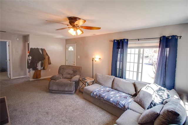 living room with visible vents, baseboards, carpet, and a ceiling fan