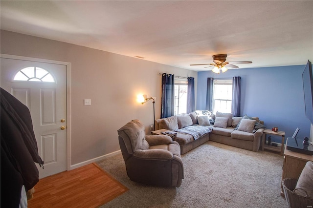 living room featuring wood finished floors, baseboards, and ceiling fan