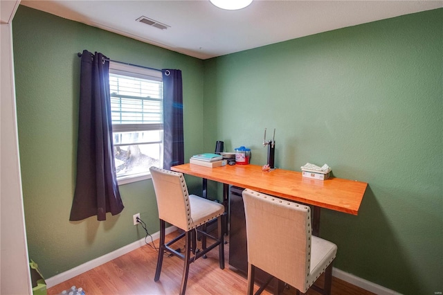 home office featuring visible vents, baseboards, and wood finished floors