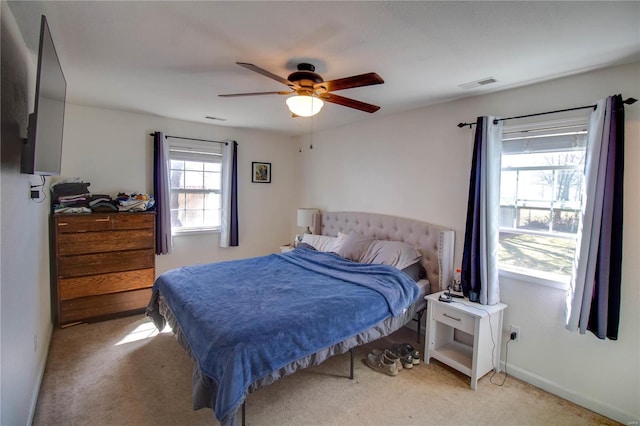 bedroom featuring light carpet, baseboards, visible vents, and ceiling fan