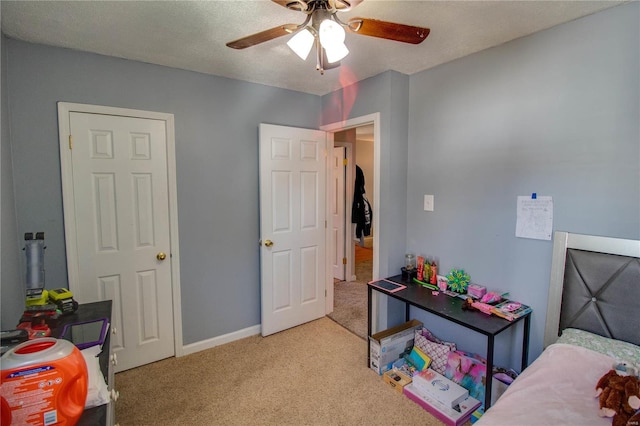 bedroom with baseboards, carpet, ceiling fan, and a textured ceiling