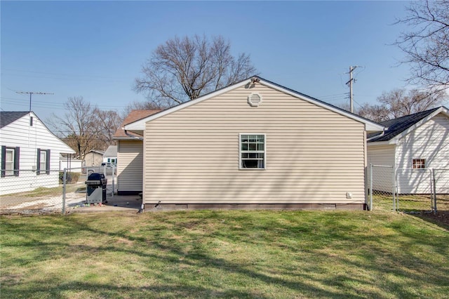 view of side of home with a yard and fence