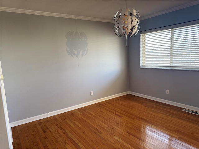 unfurnished room featuring visible vents, baseboards, crown molding, and hardwood / wood-style flooring