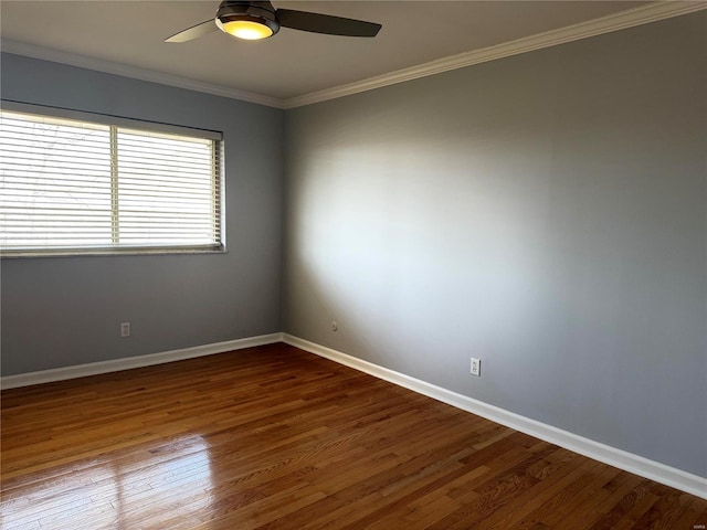 spare room featuring ceiling fan, baseboards, dark wood finished floors, and ornamental molding