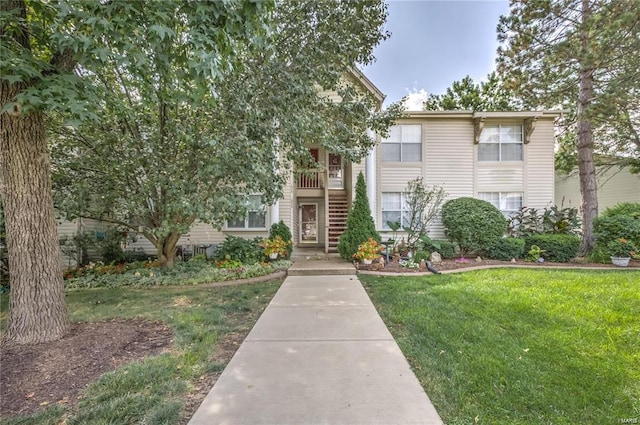 view of front of house featuring stairs and a front yard