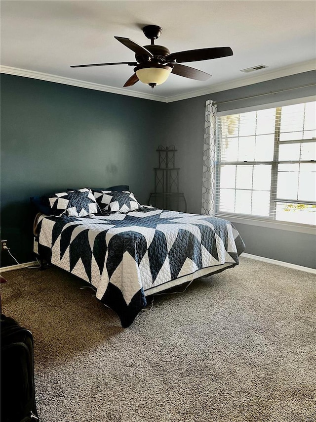 carpeted bedroom with ceiling fan, baseboards, visible vents, and ornamental molding