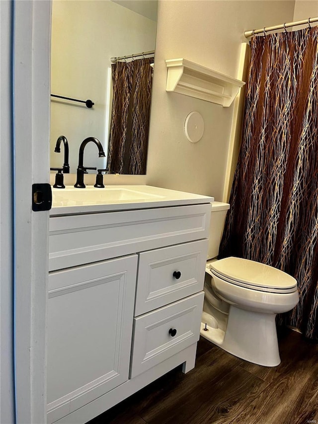 full bathroom featuring a shower with shower curtain, toilet, vanity, and wood finished floors