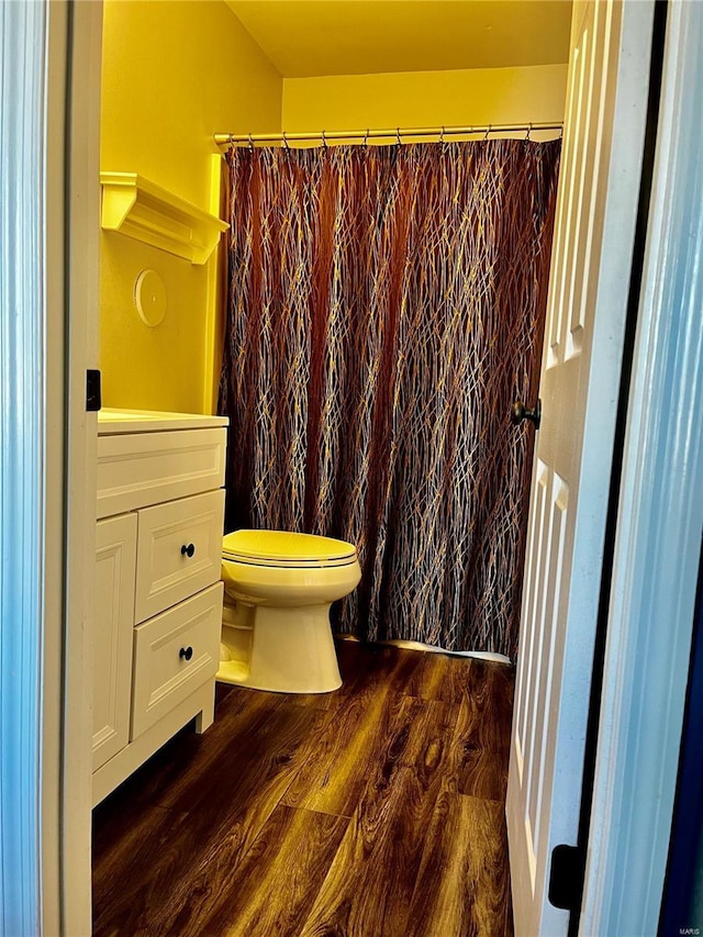 full bath featuring curtained shower, toilet, vanity, and wood finished floors