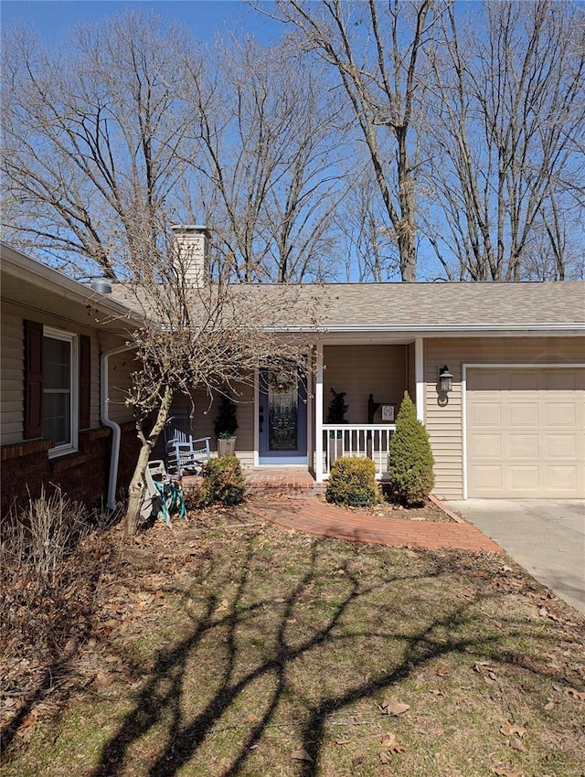 ranch-style home featuring a front yard, an attached garage, covered porch, and a chimney