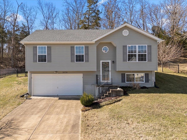 split foyer home featuring a shingled roof, a front lawn, fence, driveway, and an attached garage