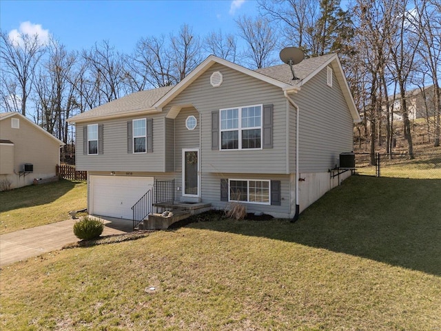 split foyer home featuring a front lawn, fence, central air condition unit, concrete driveway, and an attached garage