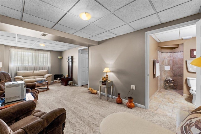 carpeted living room with a drop ceiling, baseboards, and visible vents