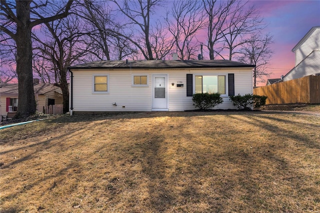 ranch-style home with a front lawn and fence