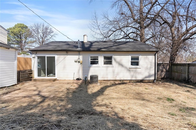 back of property with central AC unit and a fenced backyard