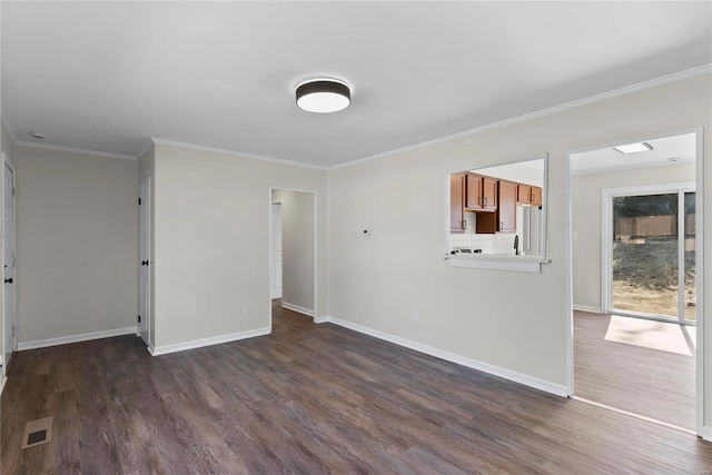 unfurnished room featuring dark wood finished floors, baseboards, and ornamental molding