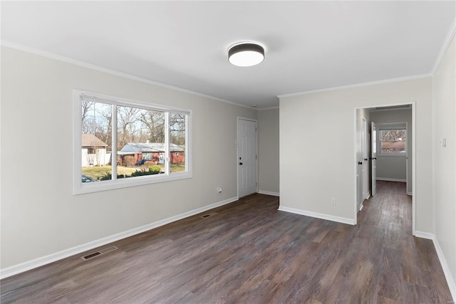 empty room featuring visible vents, baseboards, plenty of natural light, and dark wood finished floors