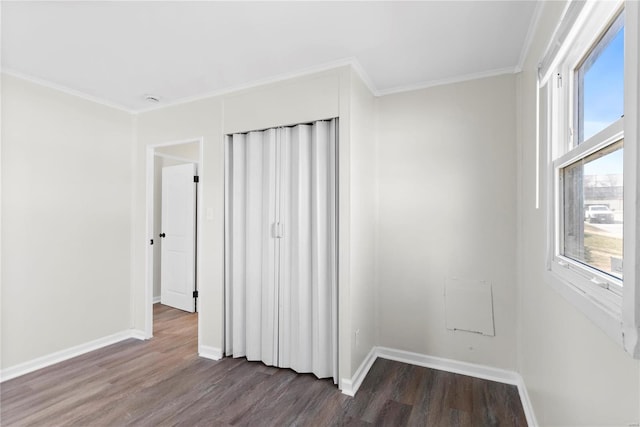 unfurnished bedroom with crown molding, dark wood-style floors, and baseboards