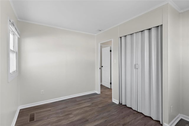 unfurnished bedroom with dark wood finished floors, baseboards, visible vents, and ornamental molding