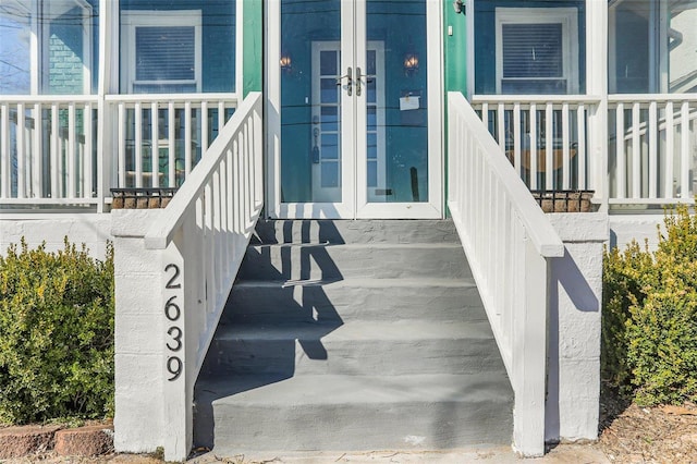 property entrance featuring covered porch and french doors