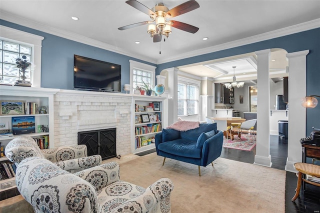 living room featuring decorative columns, a brick fireplace, and ornamental molding