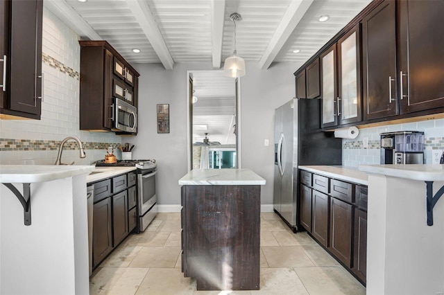 kitchen featuring stainless steel appliances, a kitchen island, dark brown cabinets, and beamed ceiling