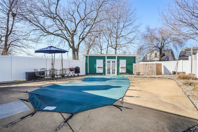 view of pool featuring french doors, a fenced backyard, and a patio area