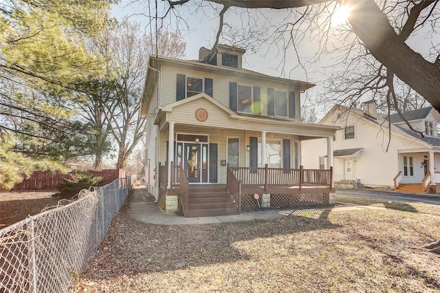 american foursquare style home with a porch and fence