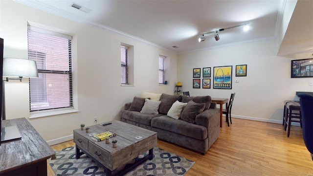 living room featuring crown molding, light wood-style floors, visible vents, and baseboards