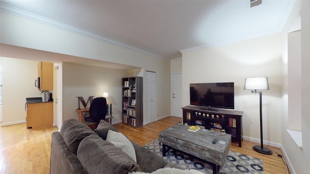 living area featuring visible vents, light wood-style flooring, baseboards, and ornamental molding