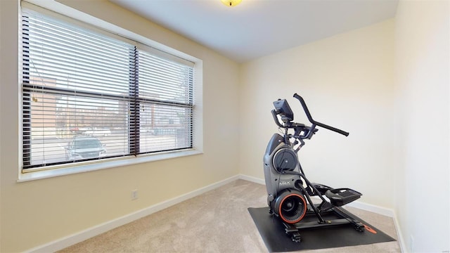 exercise room with baseboards and carpet