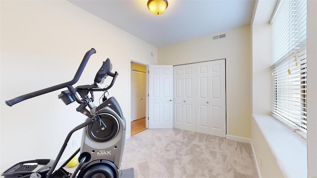 workout area featuring visible vents, baseboards, and carpet