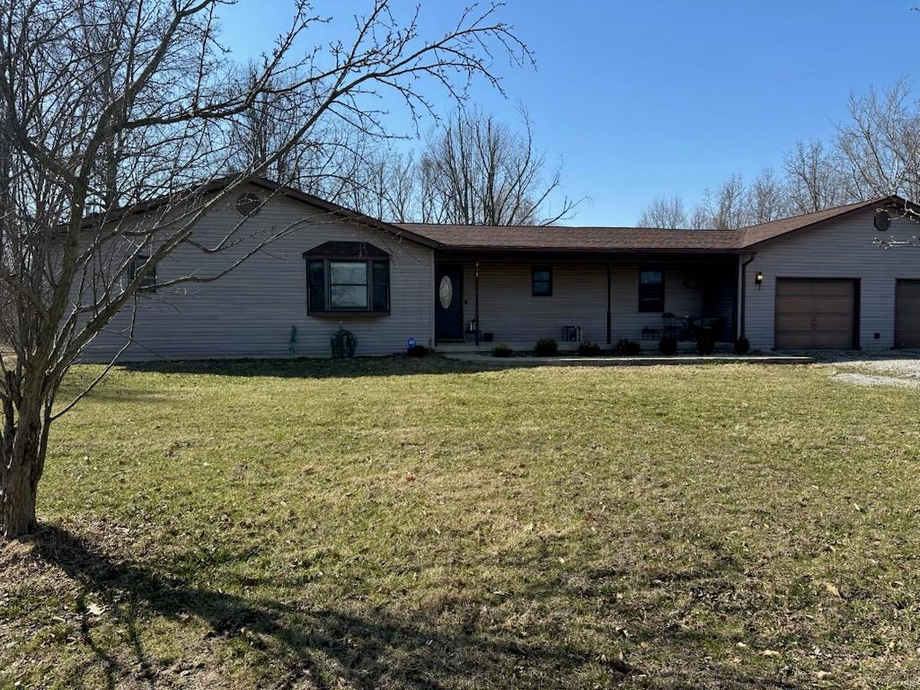 single story home featuring a front lawn, an attached garage, and driveway