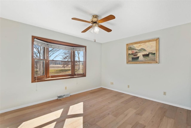 spare room with visible vents, baseboards, light wood-type flooring, and ceiling fan