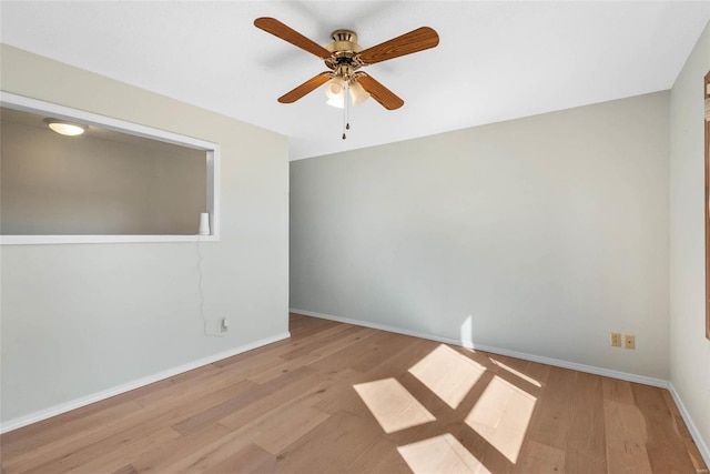 empty room featuring baseboards, ceiling fan, and wood finished floors