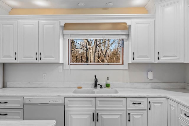 kitchen with white cabinets, dishwasher, light countertops, and a sink