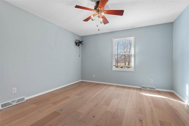 spare room with visible vents, ceiling fan, and light wood finished floors