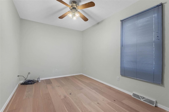 empty room featuring visible vents, baseboards, ceiling fan, and wood finished floors