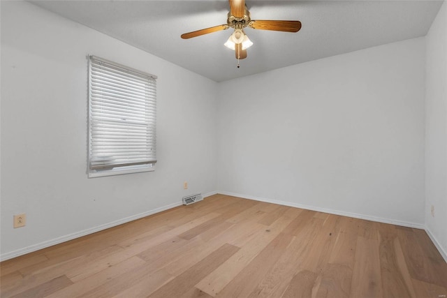 empty room with visible vents, baseboards, ceiling fan, and light wood finished floors