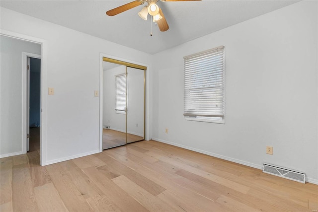 unfurnished bedroom featuring visible vents, a ceiling fan, wood finished floors, a closet, and baseboards