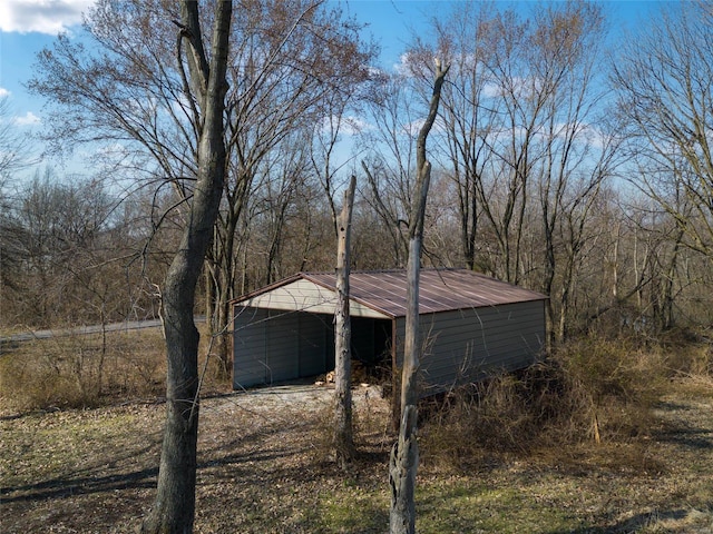 exterior space with dirt driveway, an outdoor structure, and a pole building