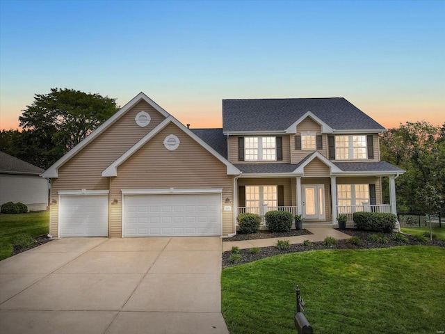 traditional-style home featuring a front yard, driveway, roof with shingles, a porch, and a garage