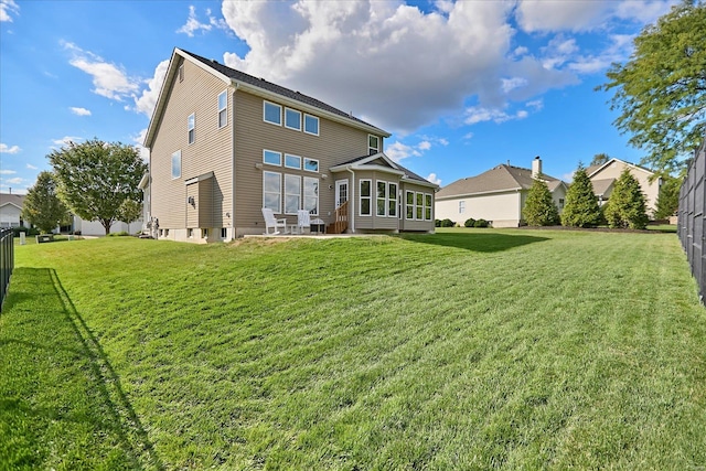 rear view of property with a yard, a sunroom, and a patio area