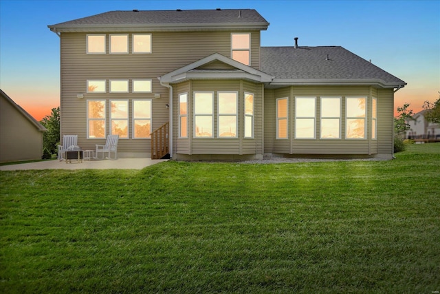 rear view of property with a patio area, a lawn, and roof with shingles