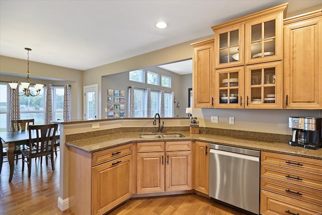 kitchen with a sink, plenty of natural light, stainless steel dishwasher, and a peninsula