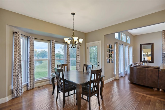 dining room with visible vents, baseboards, a notable chandelier, and dark wood finished floors