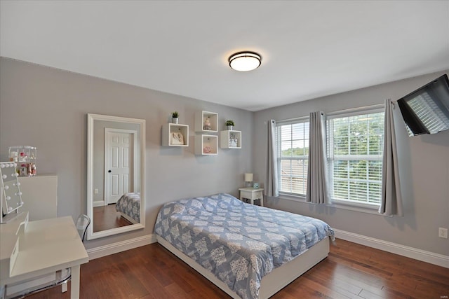 bedroom with dark wood-type flooring and baseboards