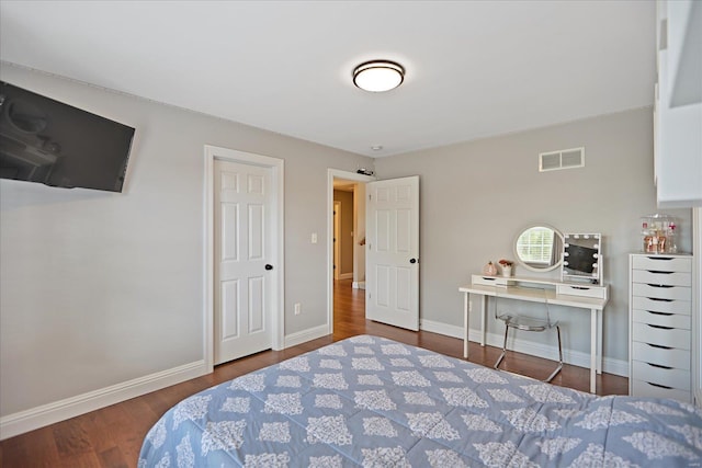 bedroom with visible vents, baseboards, and wood finished floors